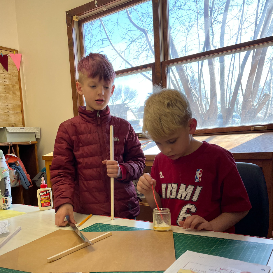 Two students painting on a table