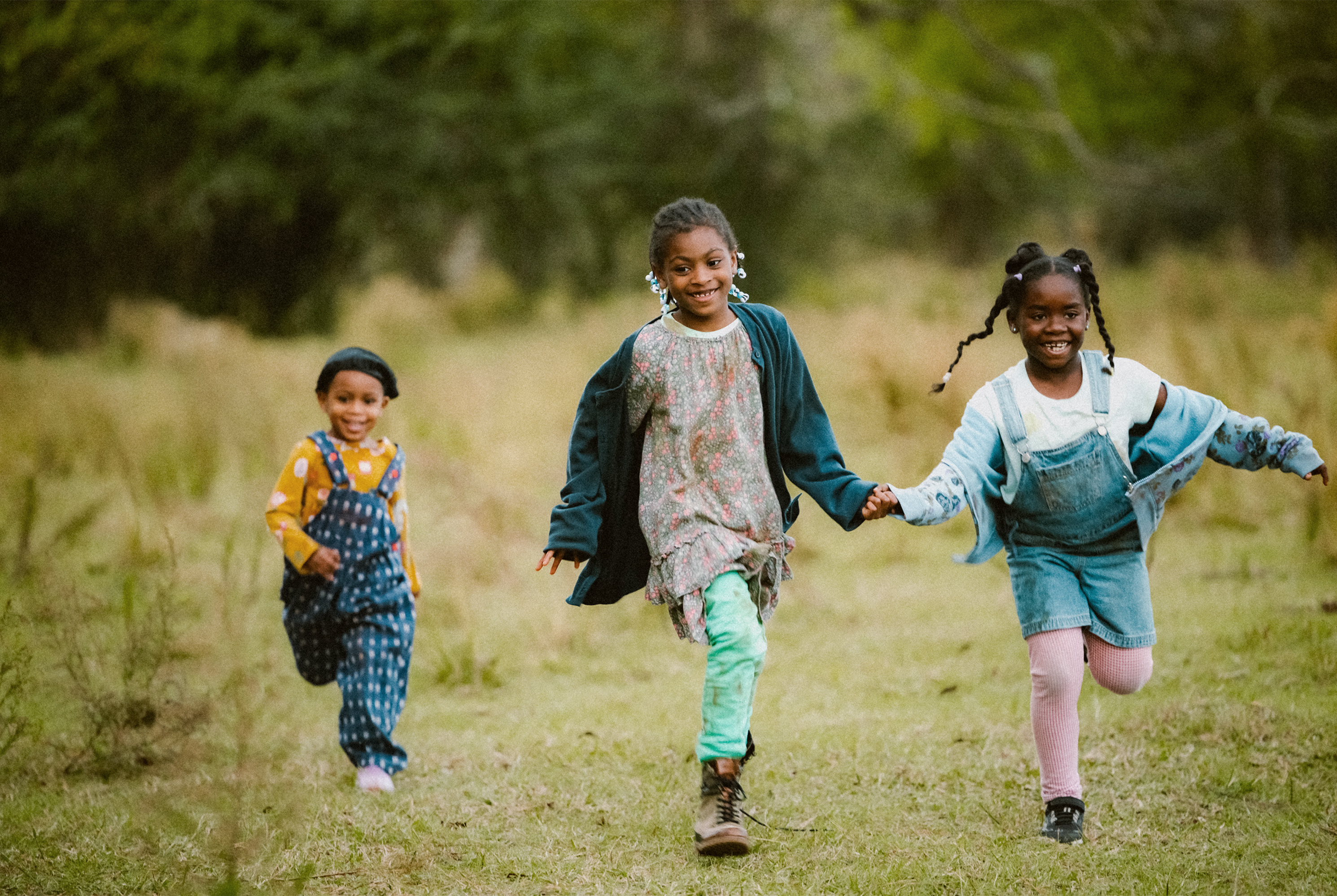 Three children playing together in a field