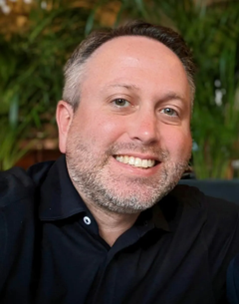 A headshot of founder Sean Segal wearing a black shirt