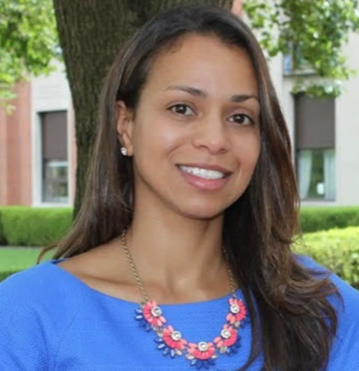 Headshot of co-founder Sienna Daniel wearing a blue shirt and orange necklace