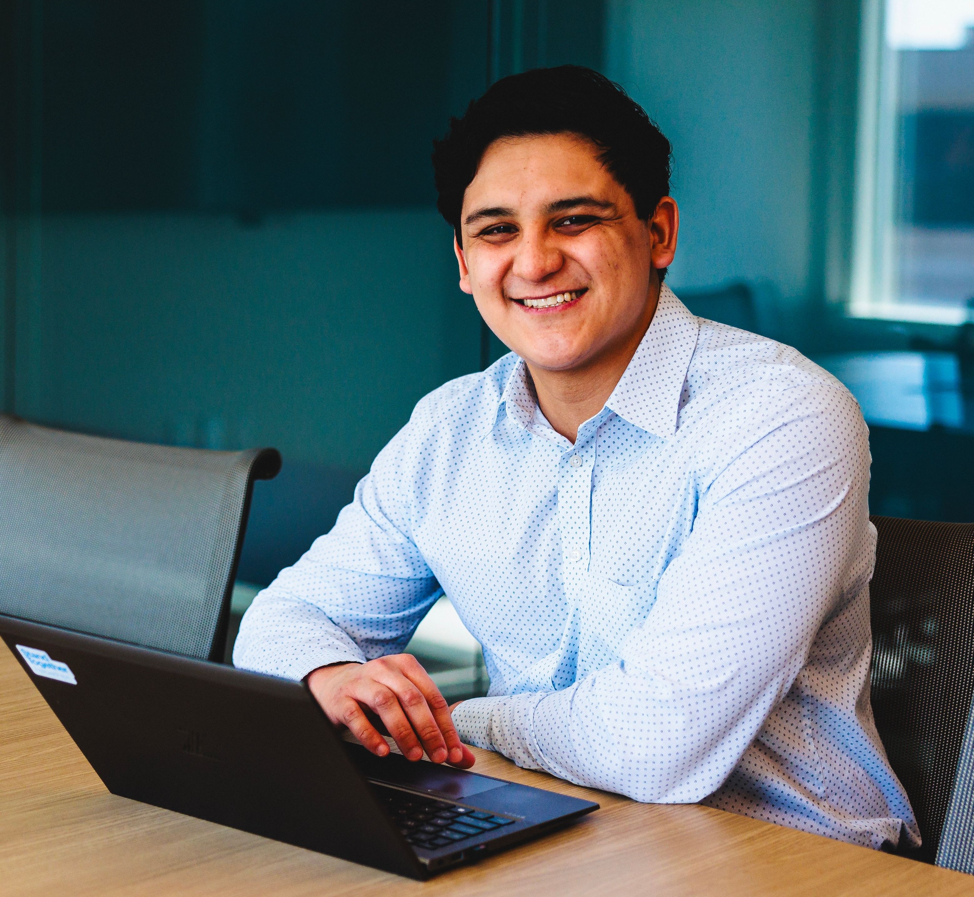 Daniel Chang Contreras smiling and working on a laptop