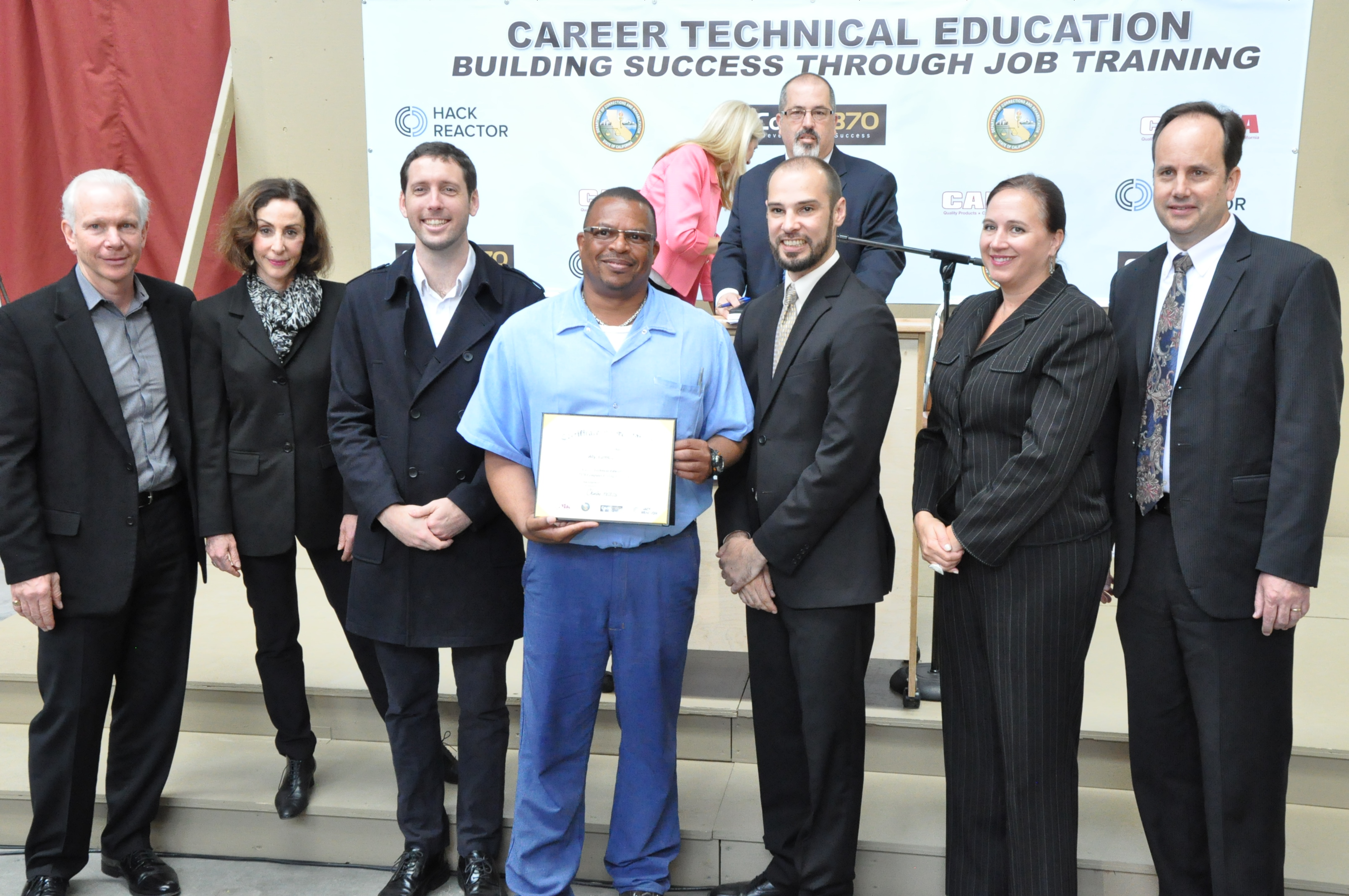 Alyssa Tamboura’s father receiving a coding certificate. The Last Mile co-founders Chris Redlitz and Beverly Parenti are on the far left.