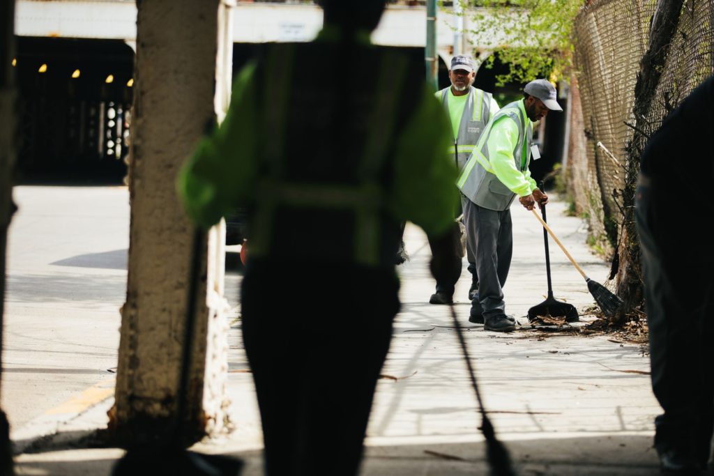 Cleanslate staff sweeping on a sidewalk
