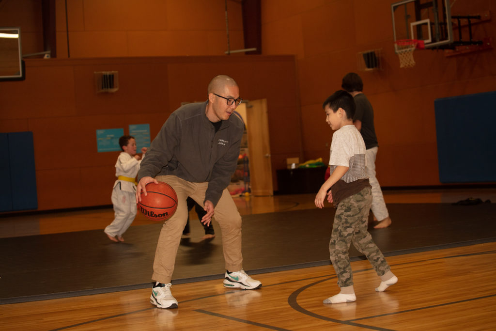 A mentor plays basketball with a mentee