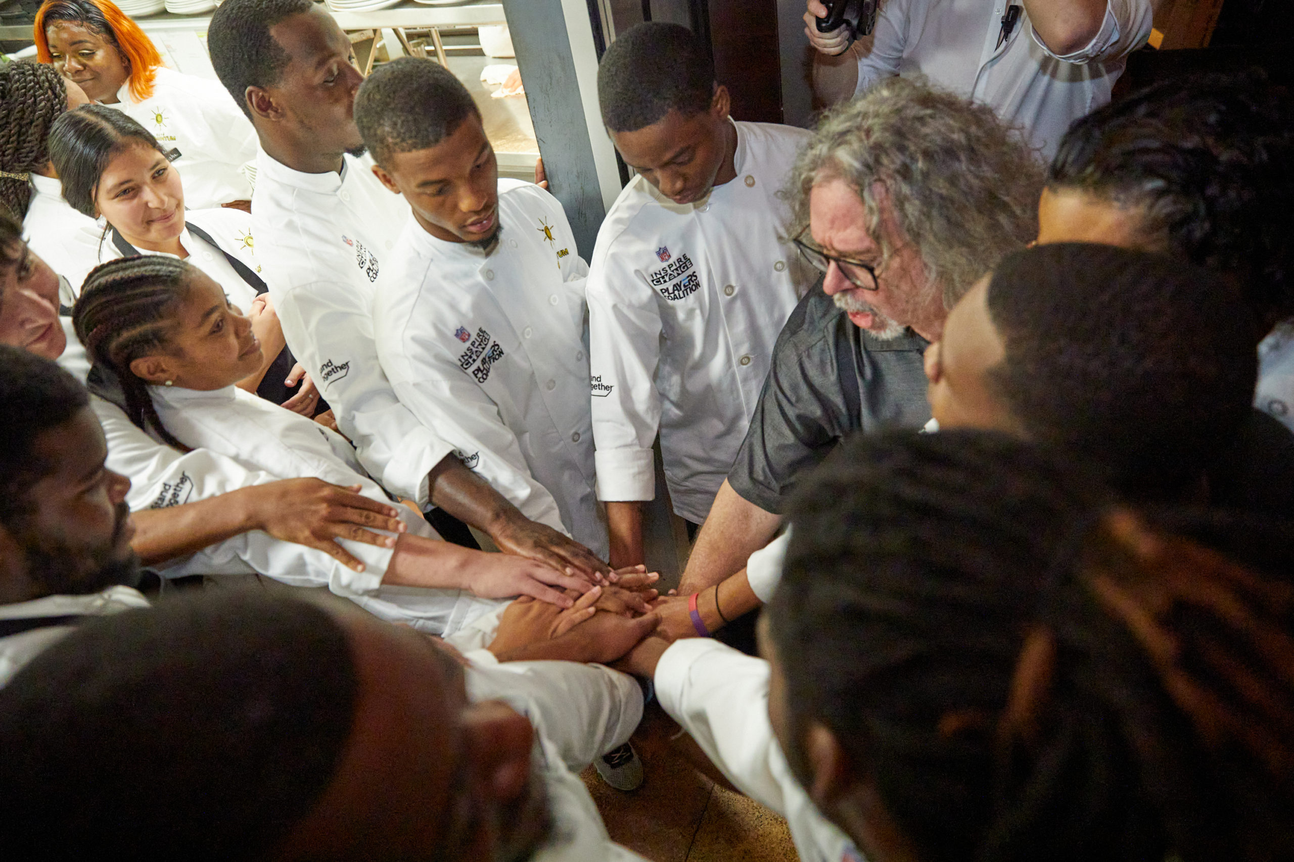Cafe Momentum interns put their hands together in a huddle
