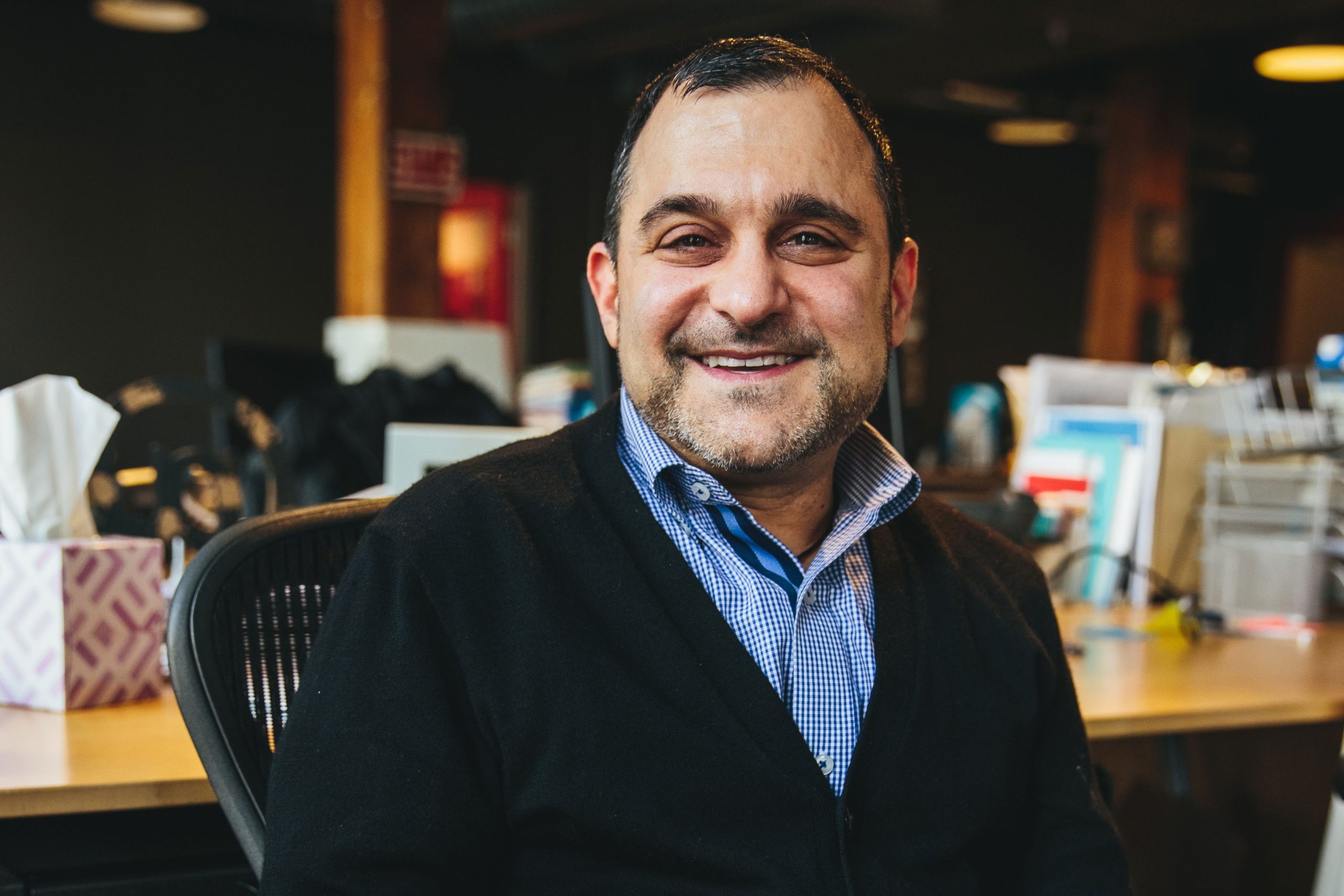 Adam Hecktman, Microsoft Philanthropies Executive, smiling while sitting at a desk