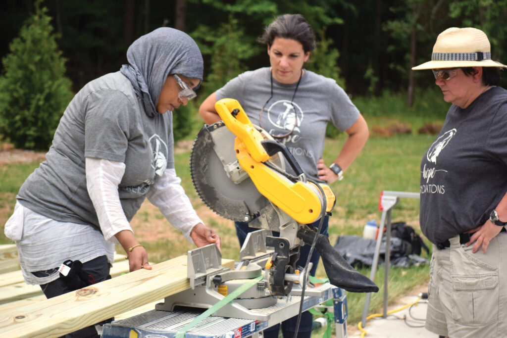 Nora El-Khouri Spencer watches a trainee use a miter saw