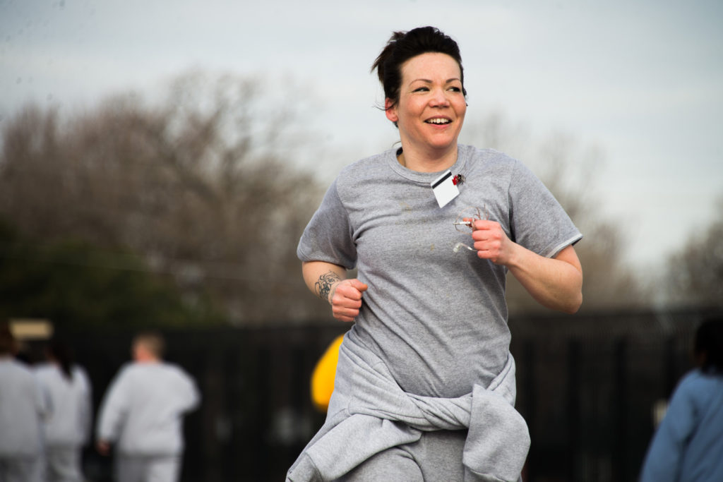 A woman smiling as she runs in the race
