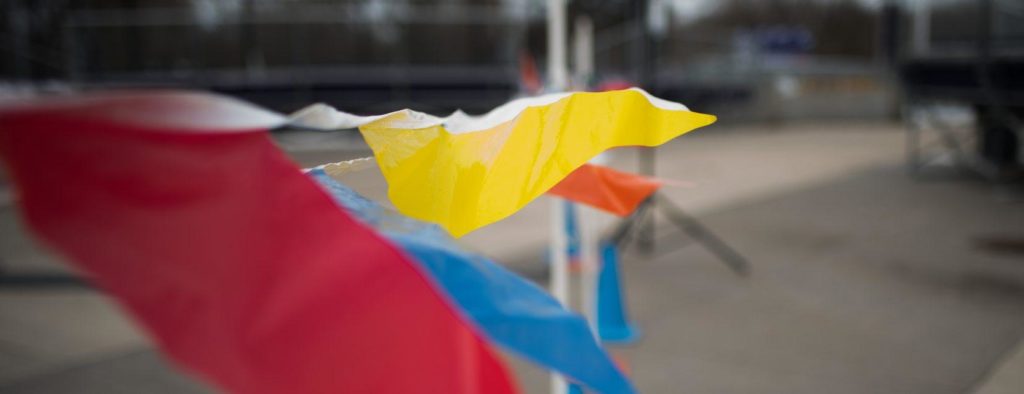 Decorative flags attached to a fence waving in the wind