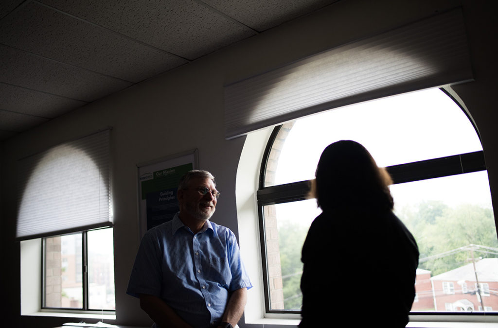 Ken Bradford, Director of Community Outreach and Resource Development speaks with someone in a hallway