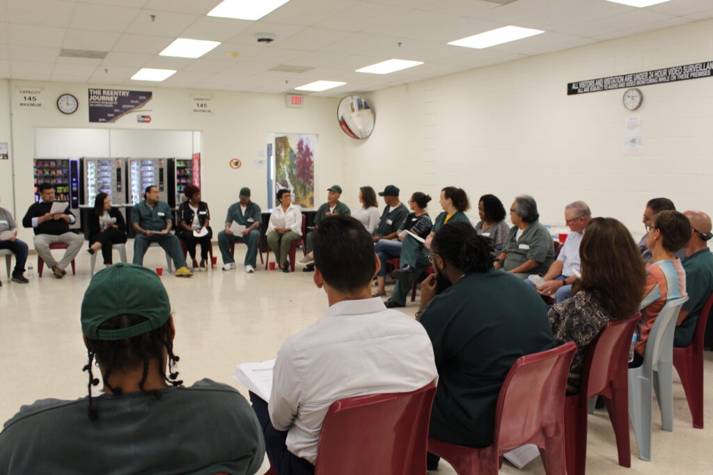 group of people sitting in chairs in a circle