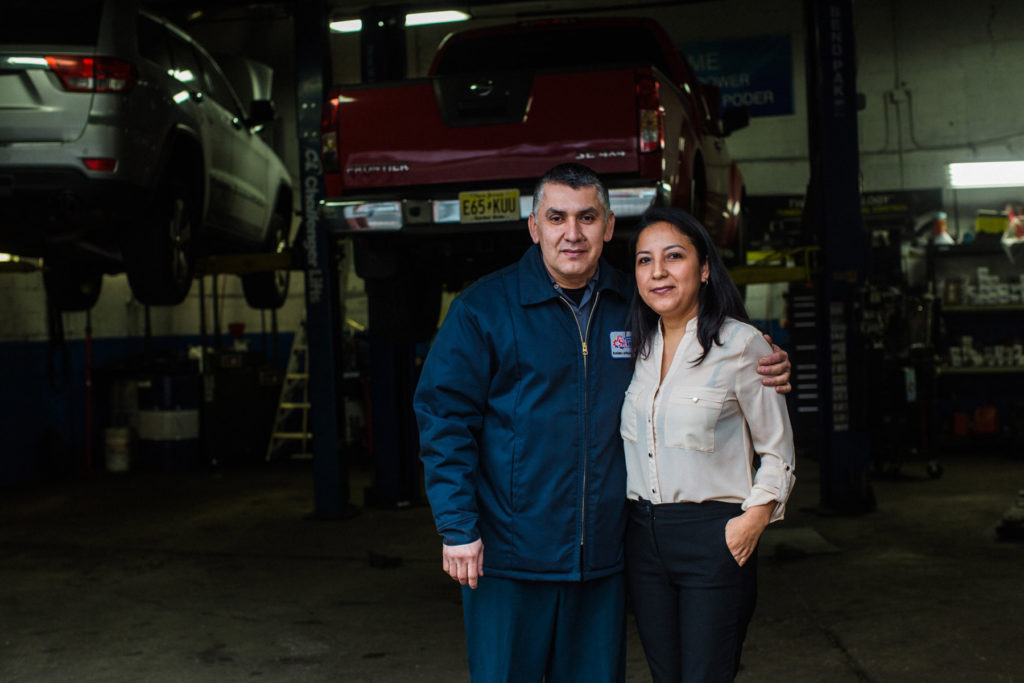 Jose and Hilda pose for a photo in front of their auto shop