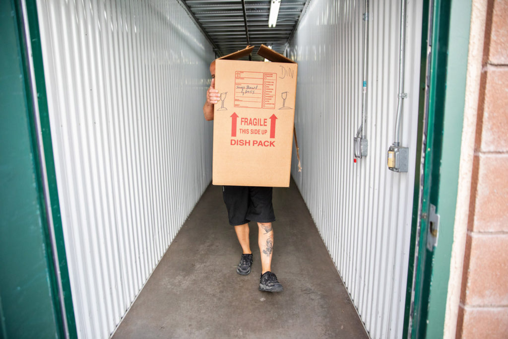 A man carries a box in a storage facility