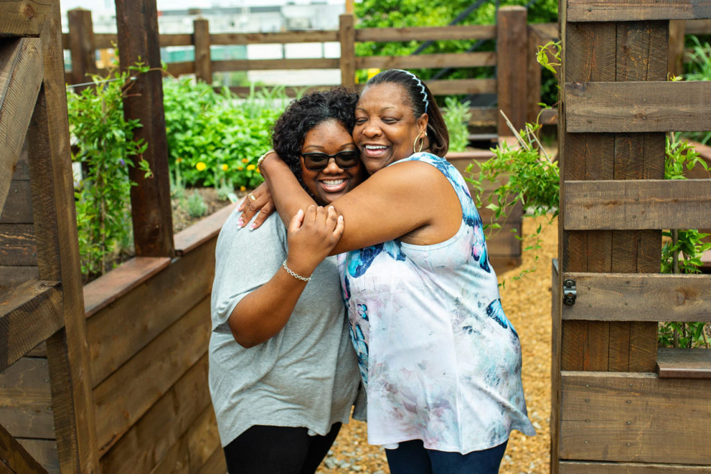 Katrina Robertson hugs her daughter, Ebony in the garden