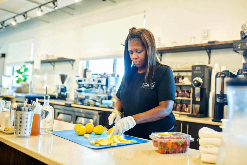 A cafe staff member cuts lemons