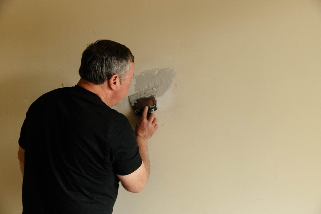 Joe puts plaster on wall