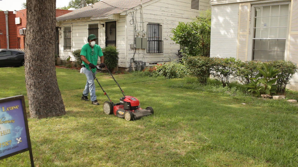 Miles of Freedom member mowing a lawn