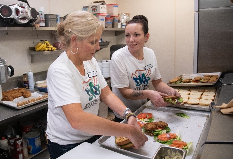 Two DV8 Kitchen staff members preparing sandwiches