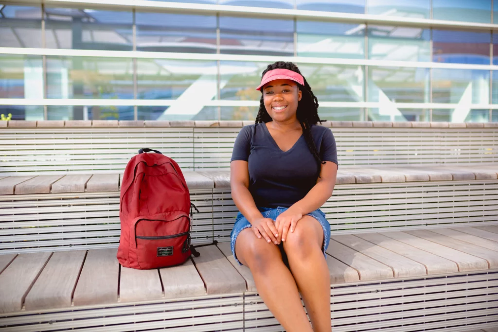 Moneythink student, gaby, with a red bookbag next to her on a bench