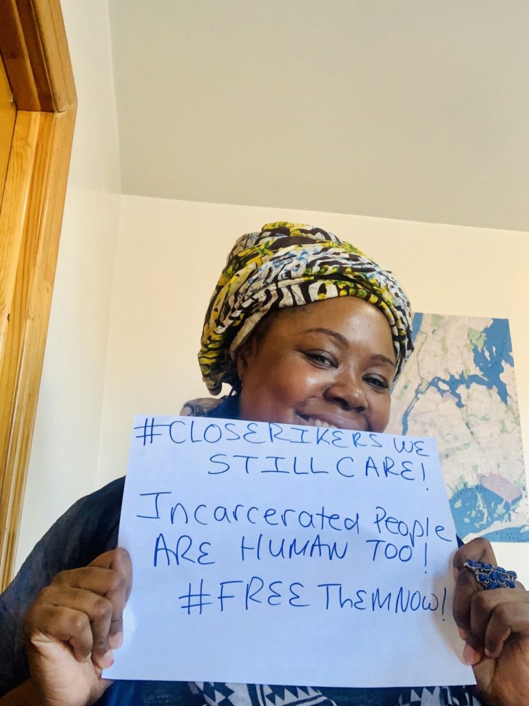 A woman holds up a sign advocating for the rights of incarcerated people