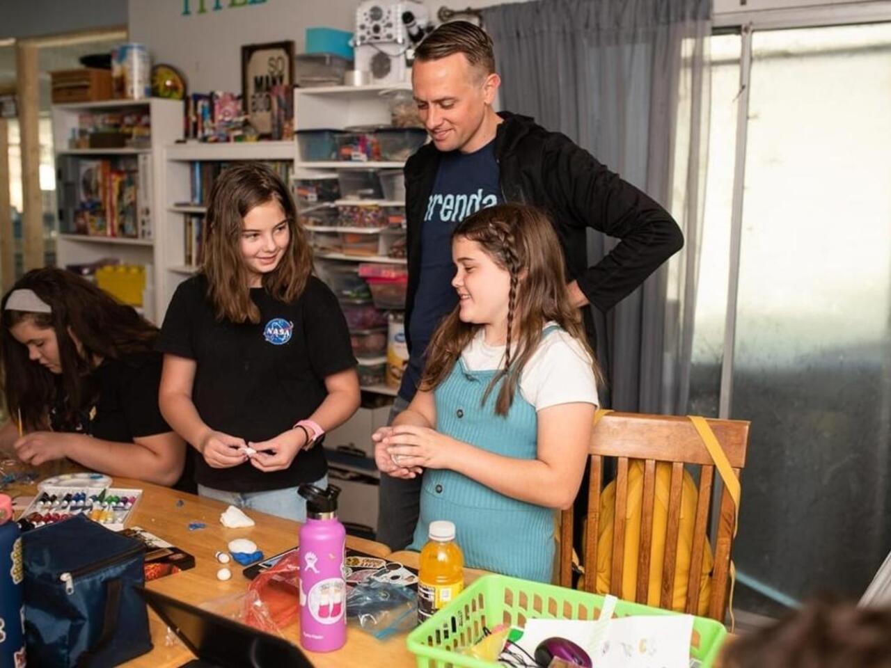 A teacher with two students making art