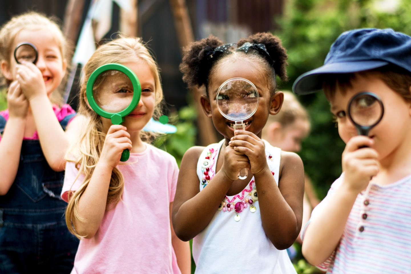 Children looking through magnifying glasses for a photo