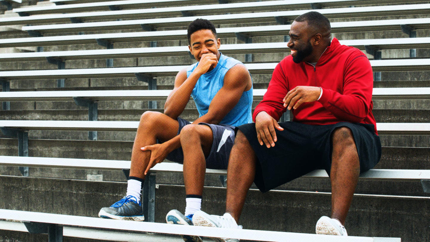 A young man and his mentor sitting on bleachers together