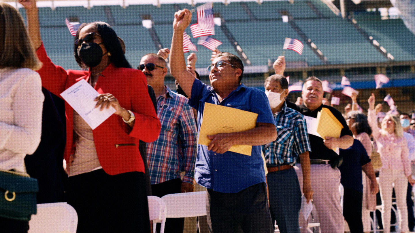 Immigrants waving American flags after becoming U.S. citizens at a naturalization ceremony in Dodger Stadium in Los Angeles