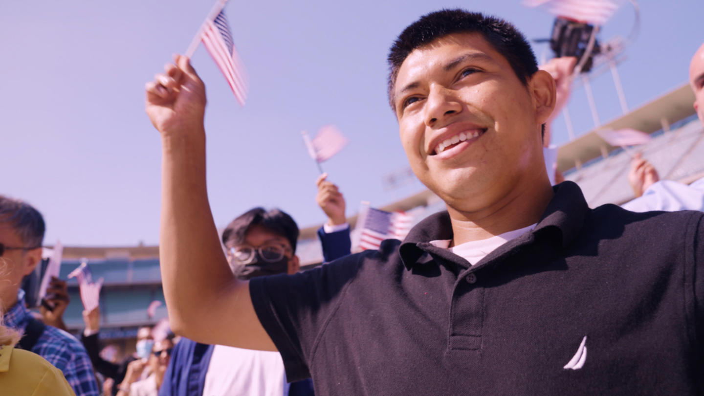 A group of people waving small American flags