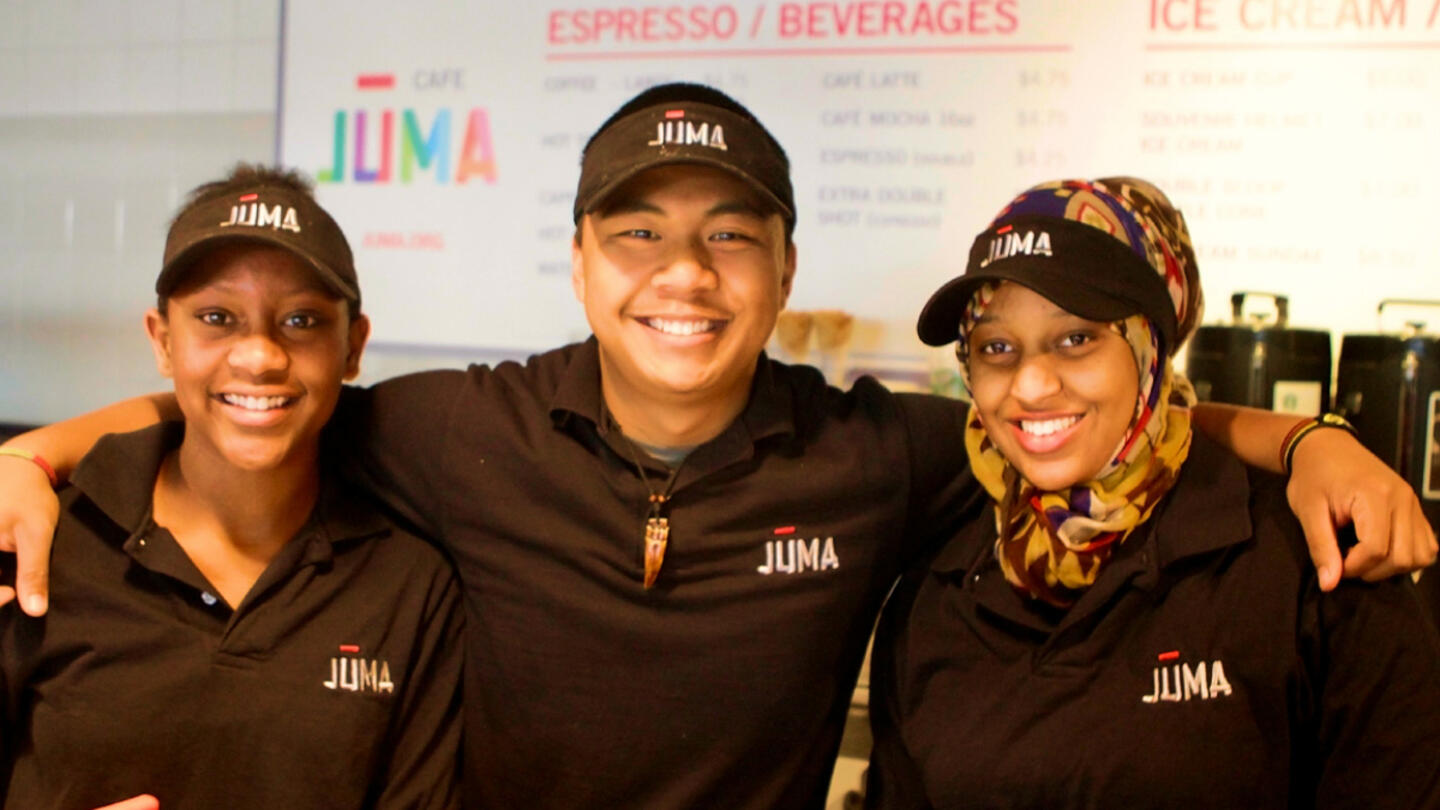 Three Juma workers wearing Juma hats and shirts.