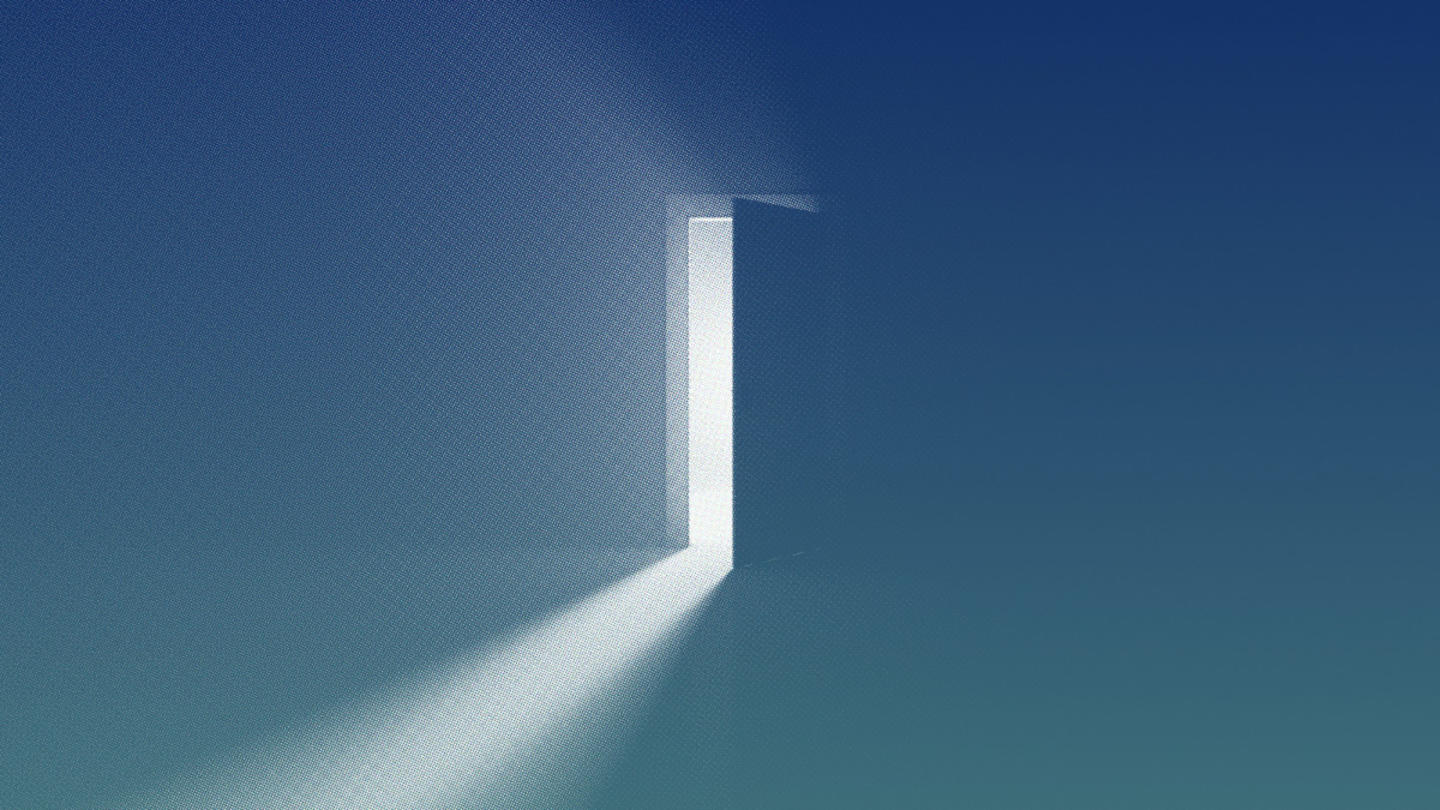 An image of a door opening in a dark room and light shining through.
