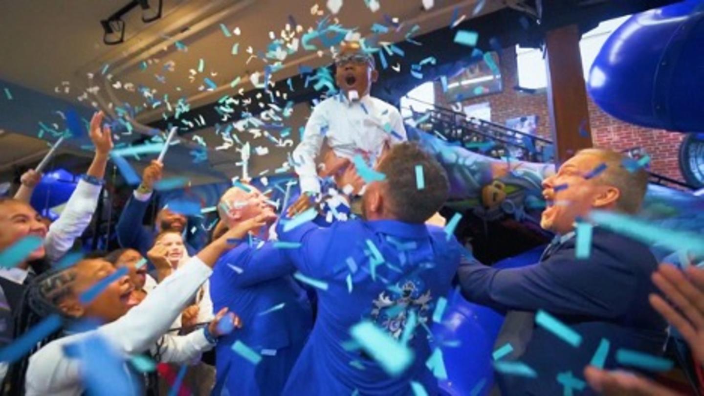 A group of people celebrate by throwing confetti in the air.