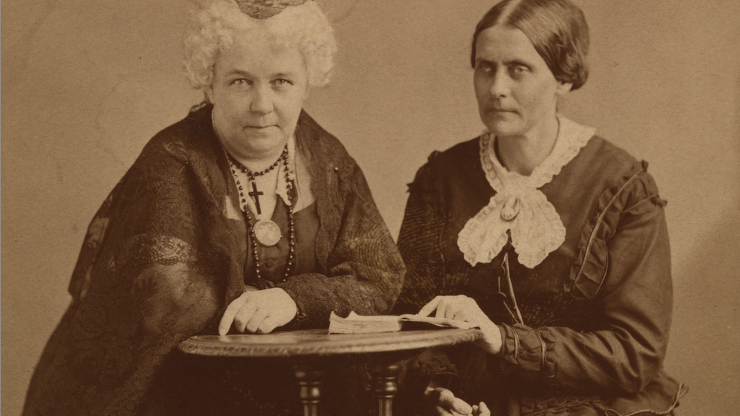 Photo of Elizabeth Cady Stanton sitting at a table with a fellow suffragette.