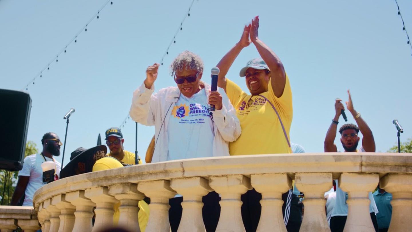 Opal Lee on a balcony celebrating Juneteenth