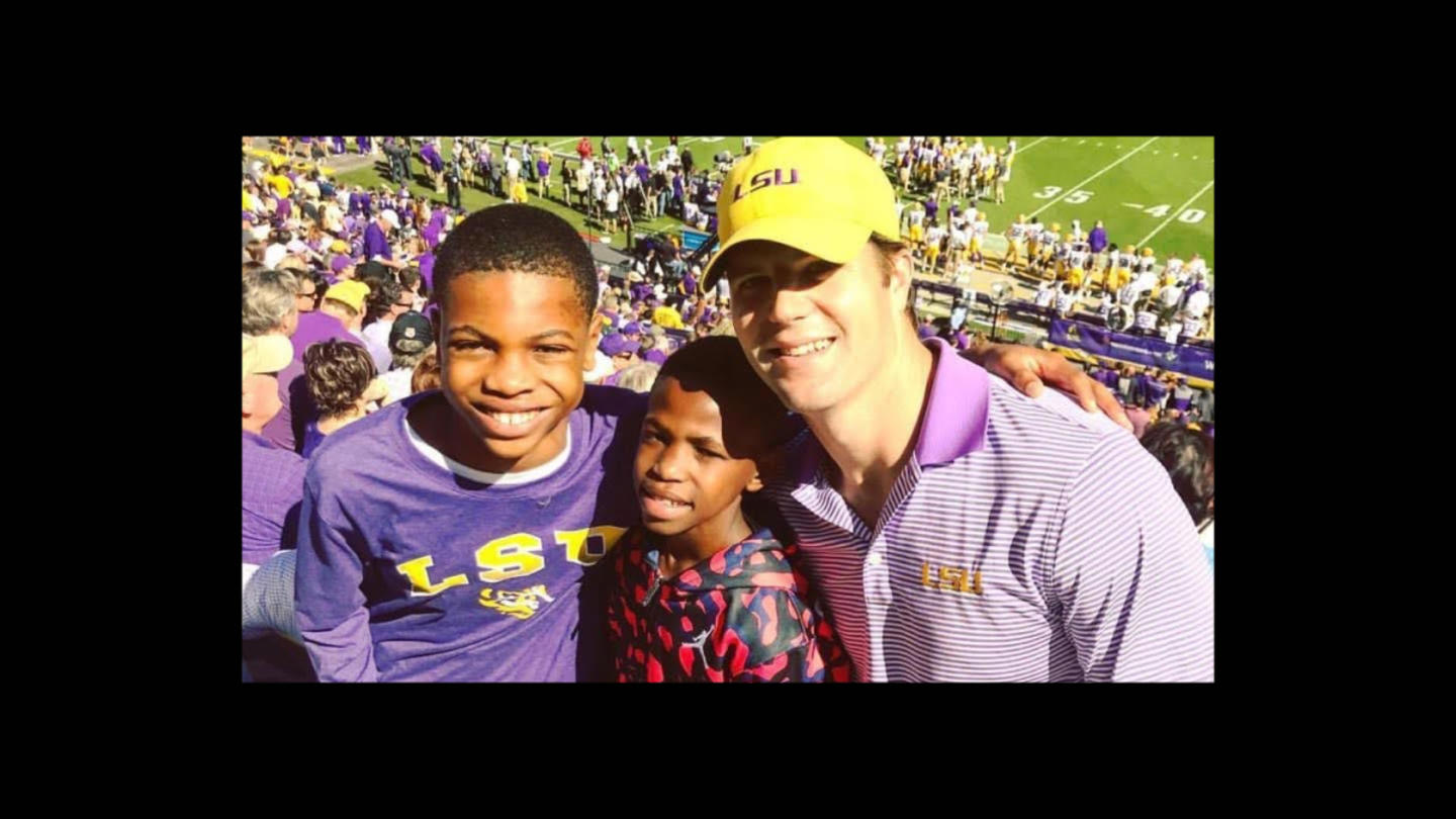 Son of Saints founder Bivian "Sonny" Lee III at a football game with two boys he mentors