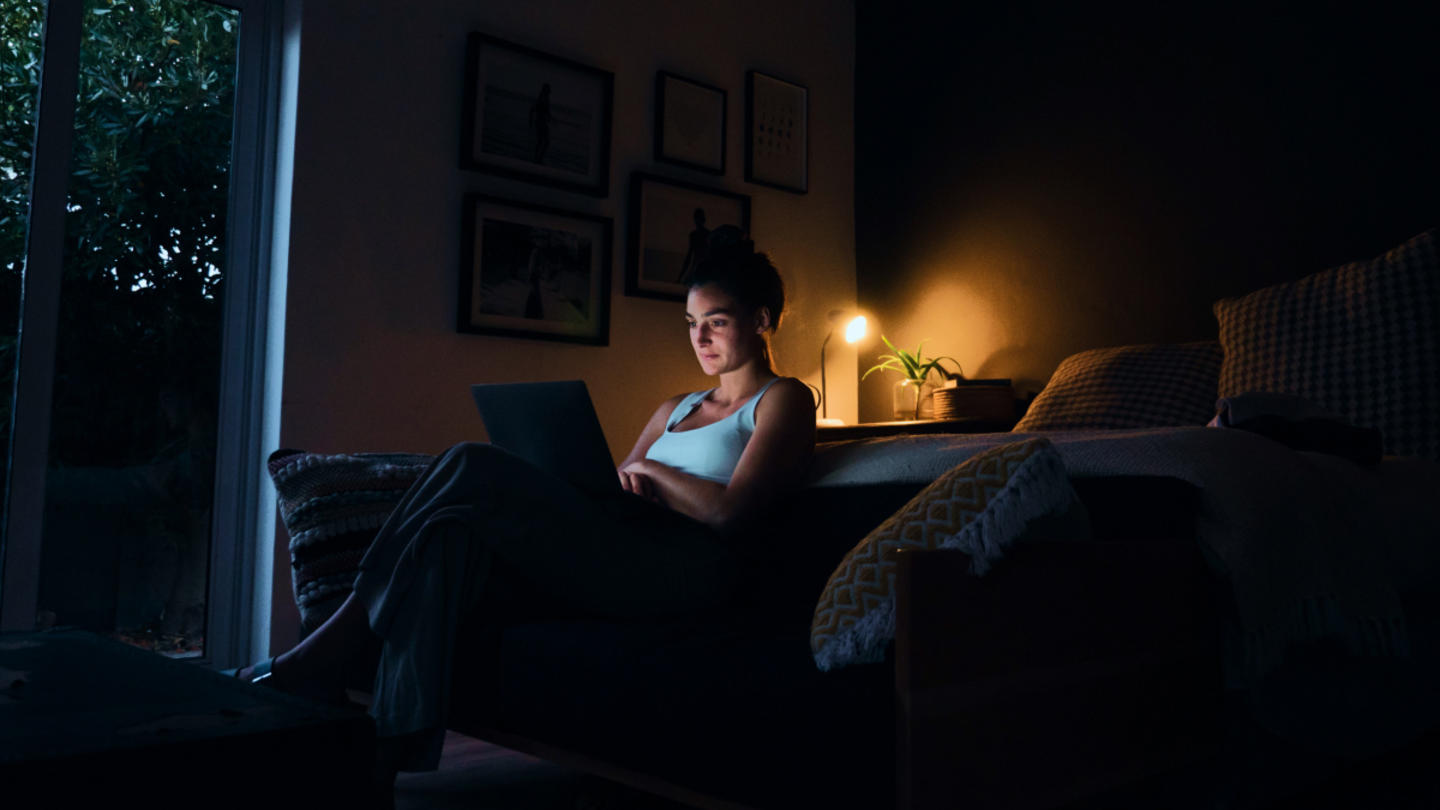 A person on their laptop during nighttime at home