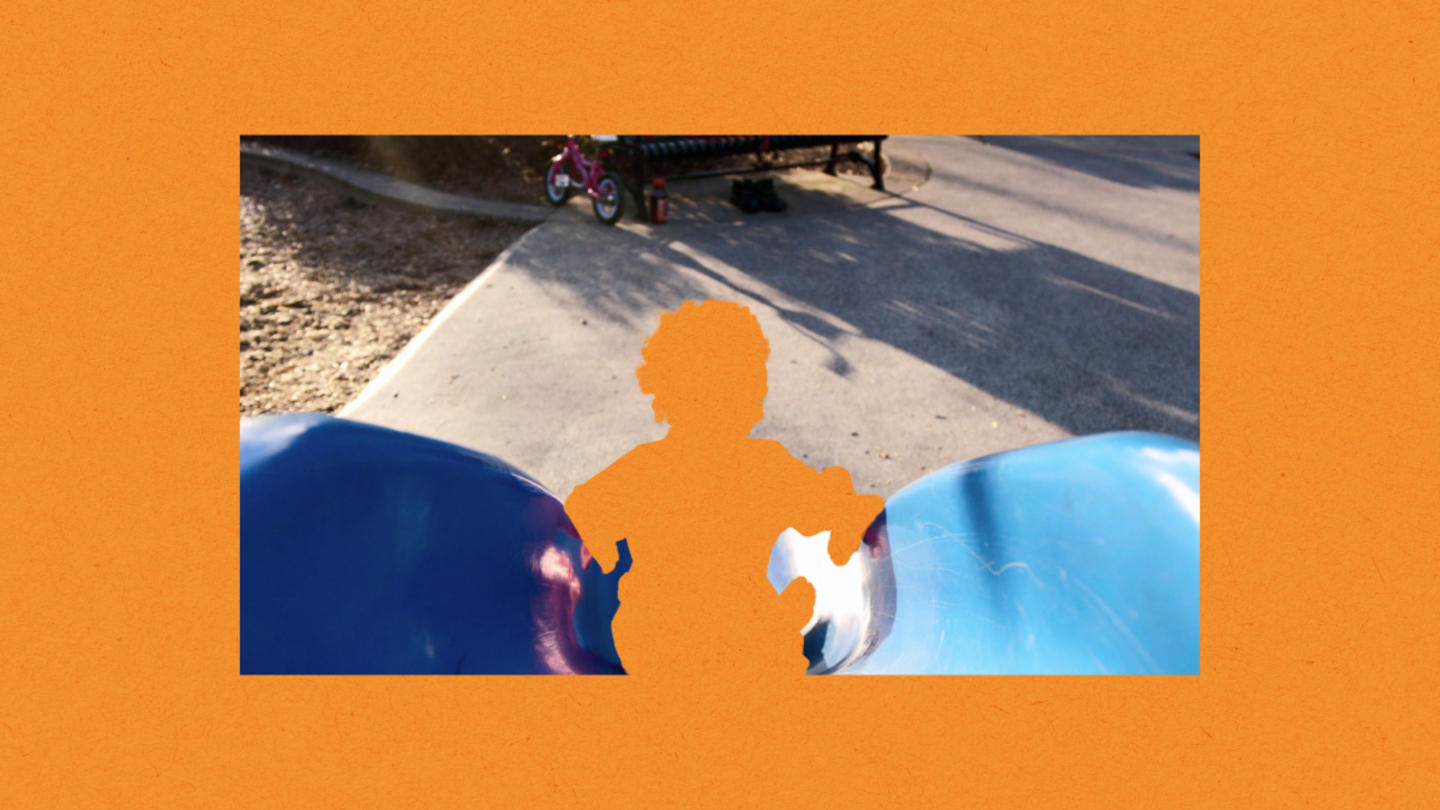 An orange cutout of a child going down a slide