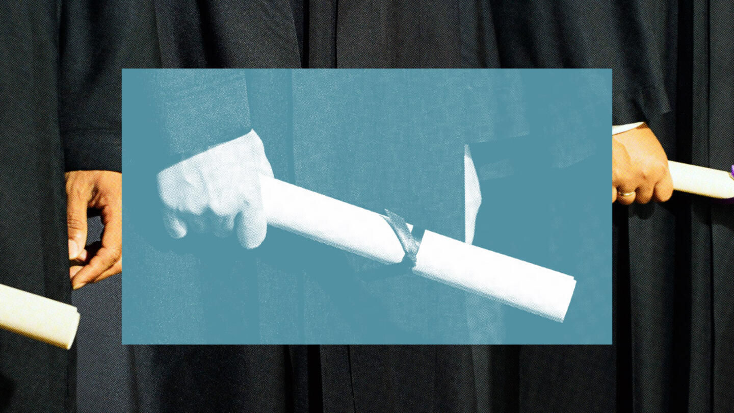 A person's hand holding a diploma