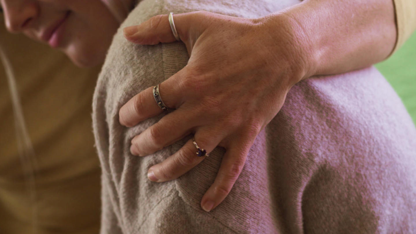 A woman being hugged and comforted