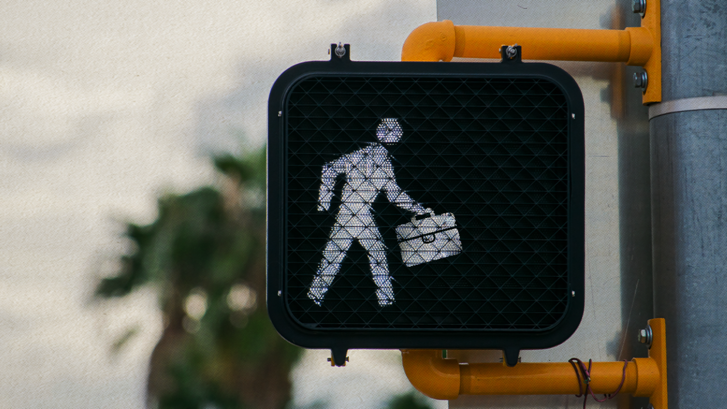 A crosswalk sign where the figure is holding a briefcase