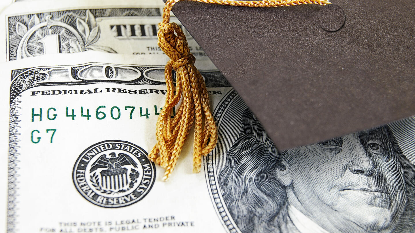 A hundred dollar bill with a graduation cap and tassle on top