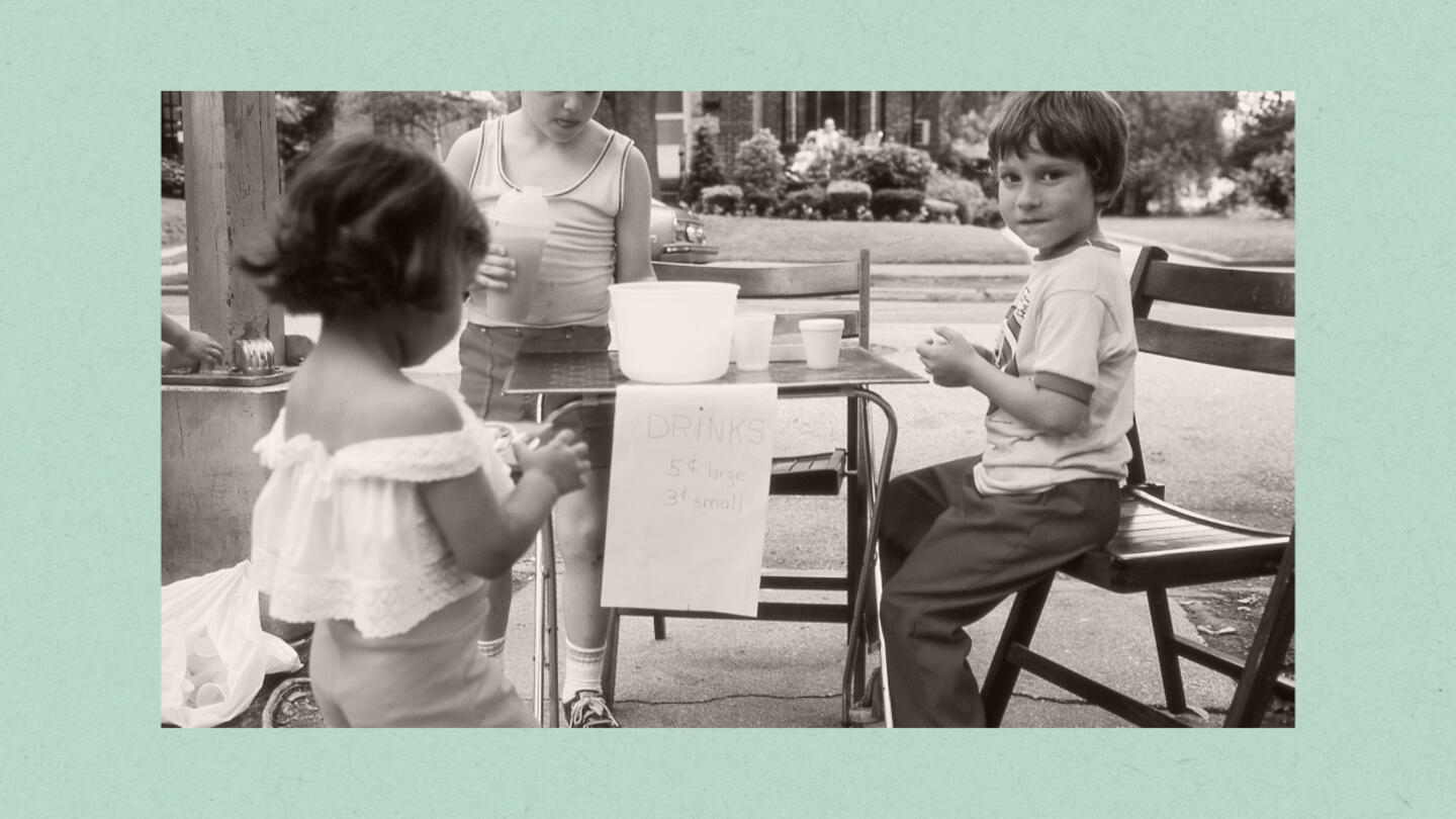 A light green border around a black and white photo of kids at a lemonade stand