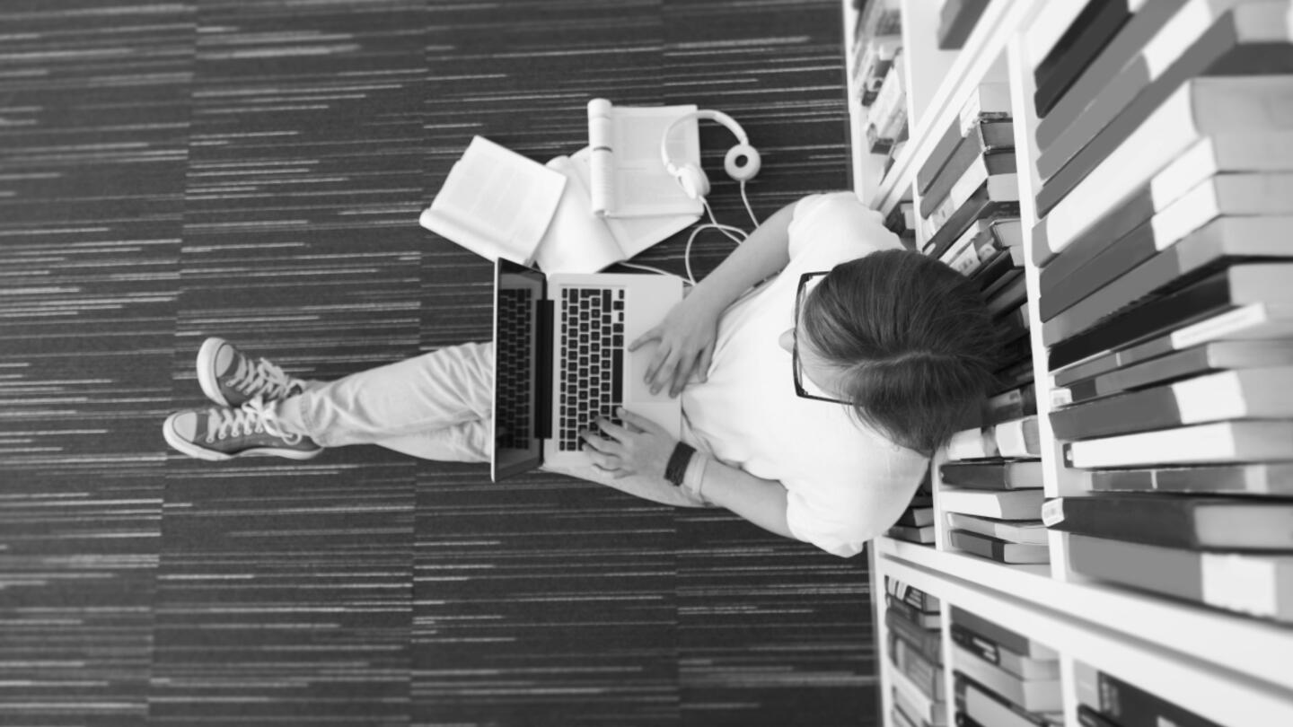 Person sitting on the ground using their laptop computer