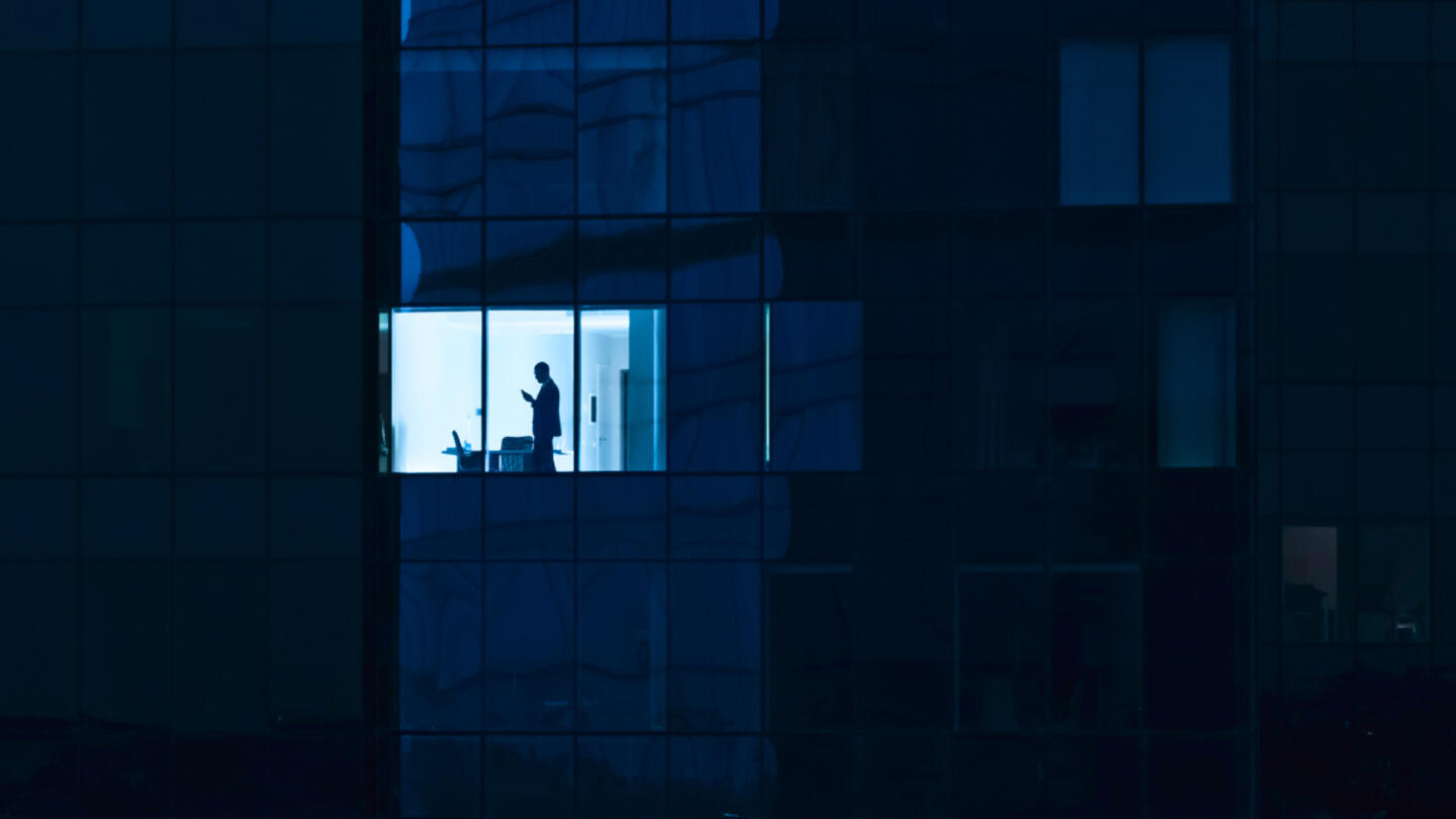 Man standing in an office at night. 