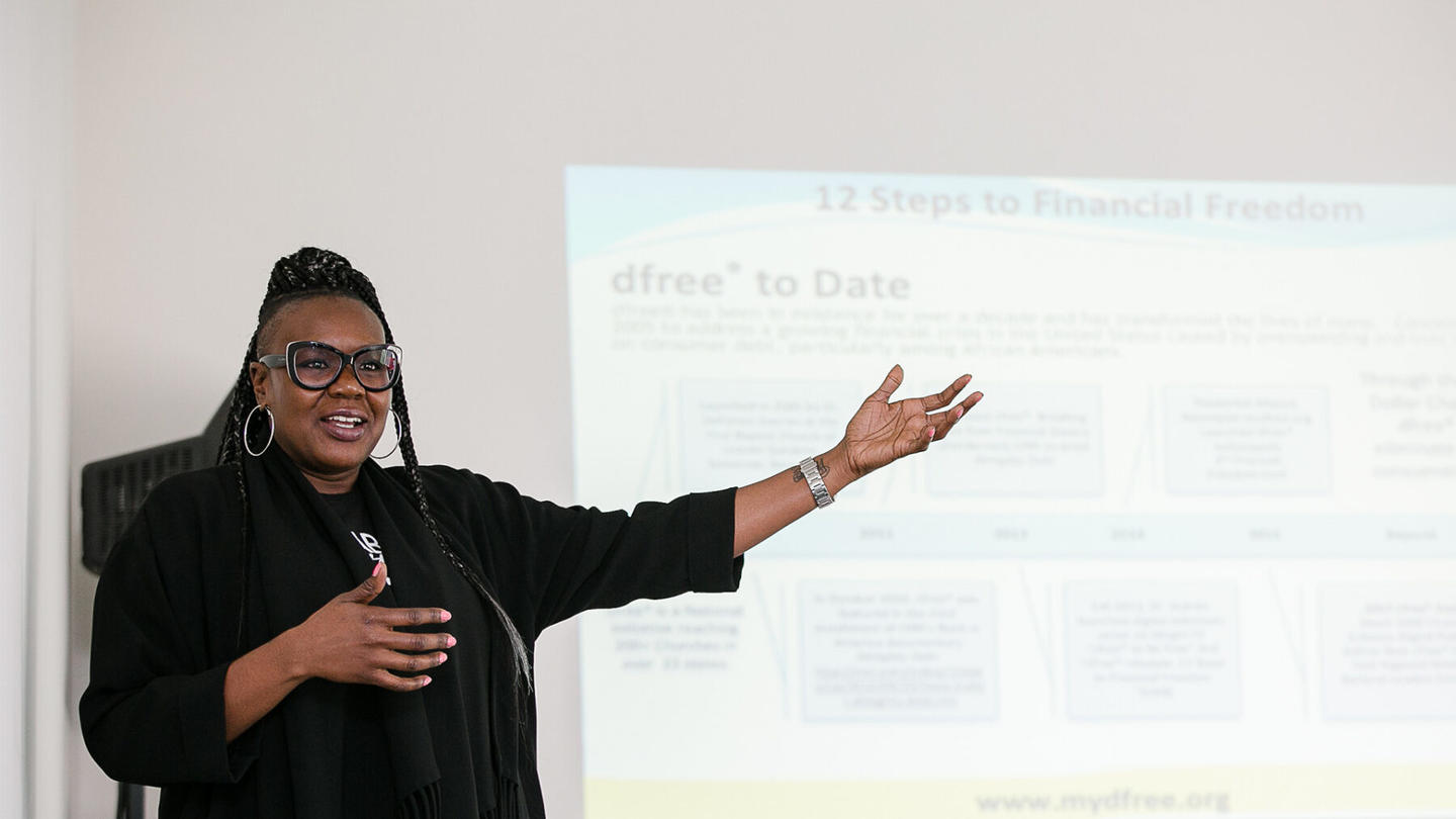 A woman gives a presentation in front of a room