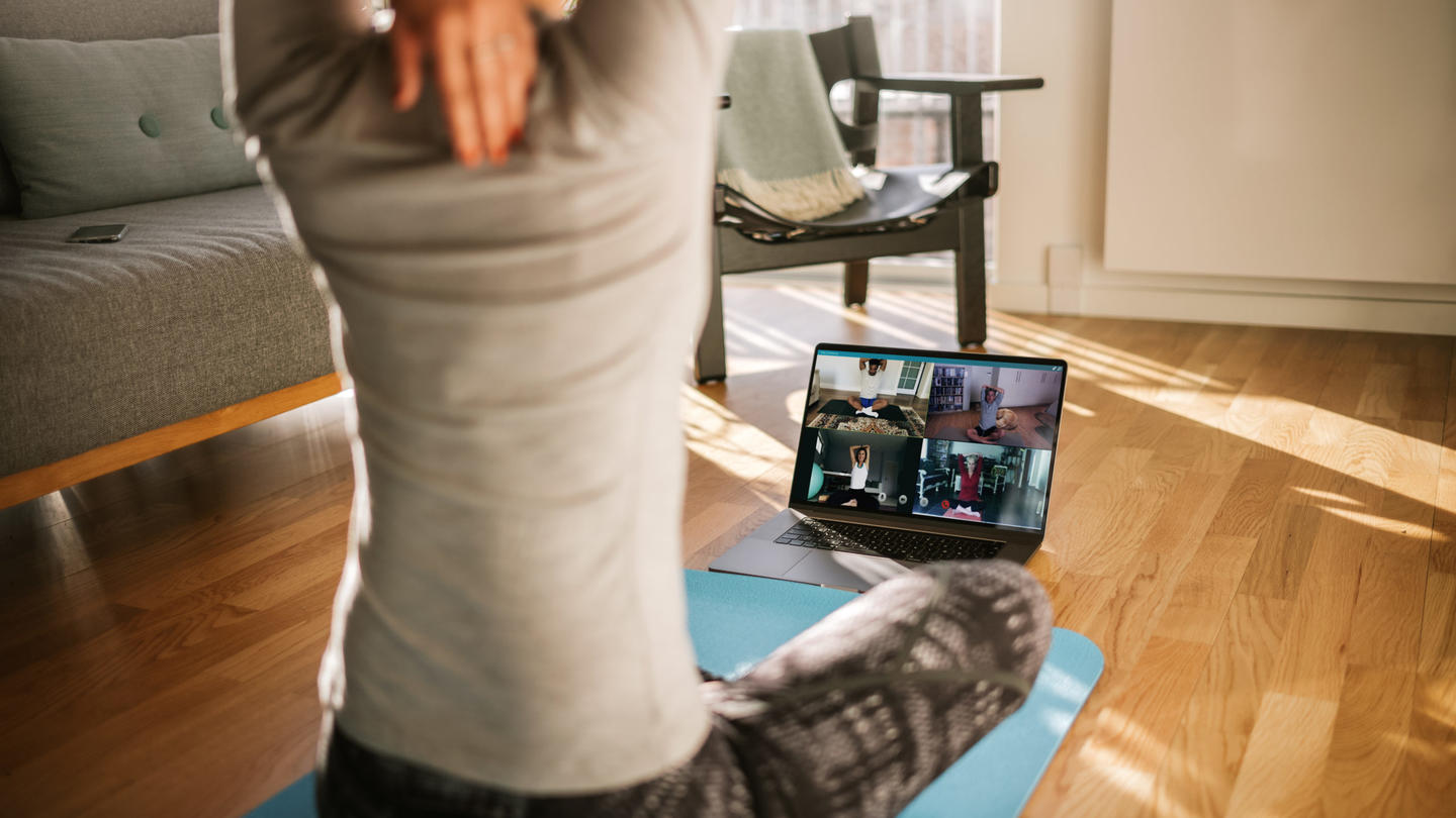 A woman stretches during a virtual yoga session