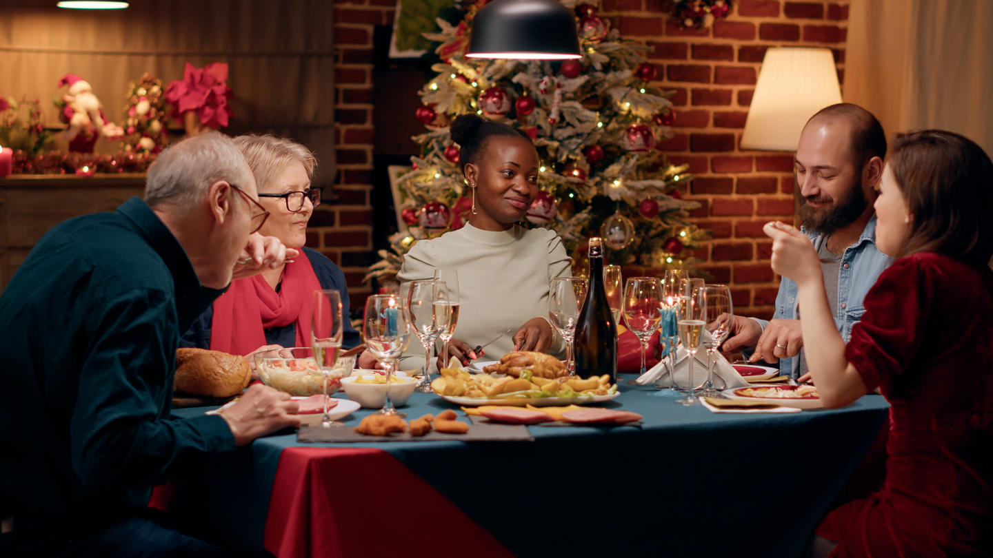 A diverse group of people gathered at a kitchen table