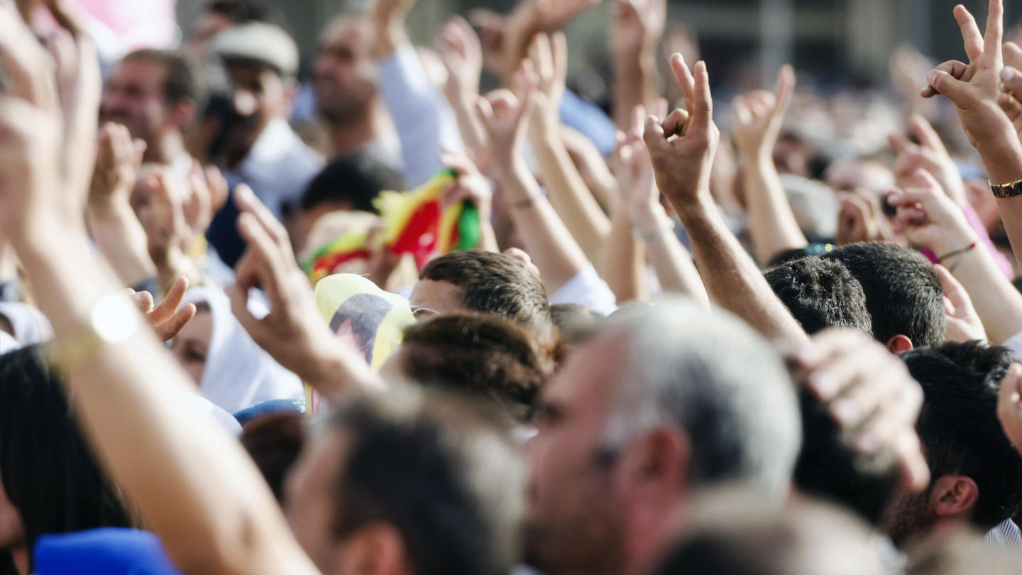 A crowd of people with their hands raised