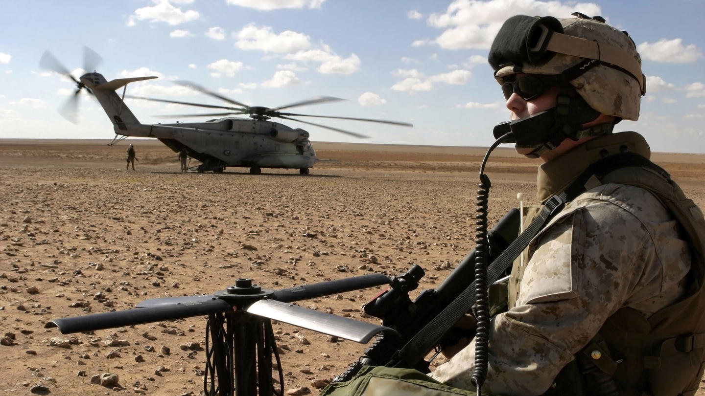A soldier posted near a helicopter in Iraq