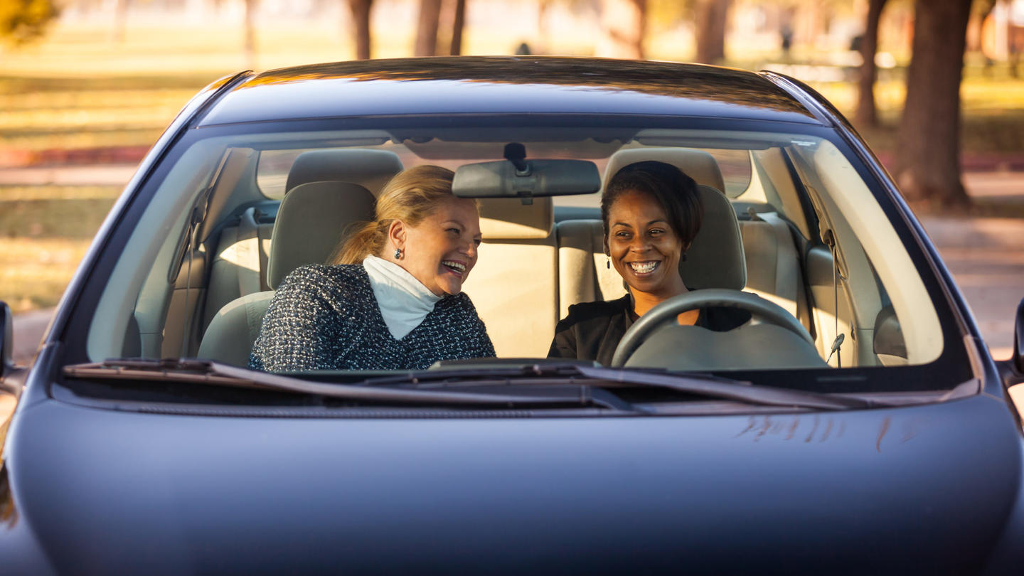 Two women in a car smiling